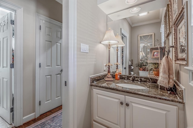 bathroom featuring ornamental molding, wood finished floors, and vanity