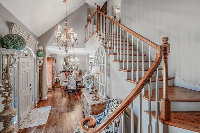 foyer featuring a chandelier, high vaulted ceiling, stairway, and wood finished floors