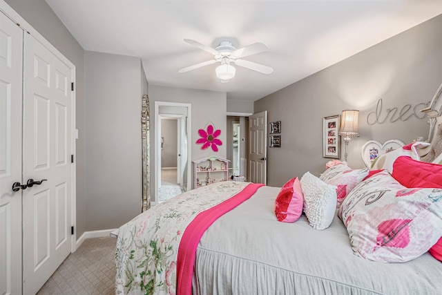 bedroom with baseboards, a closet, a ceiling fan, and light colored carpet