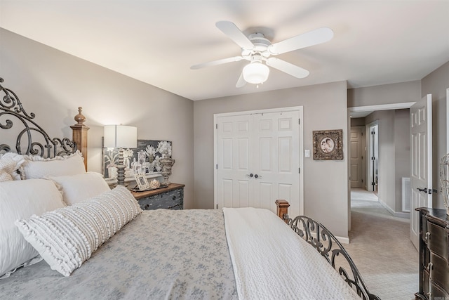 bedroom featuring ceiling fan, light carpet, visible vents, baseboards, and a closet