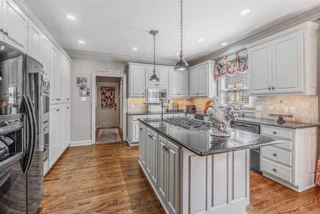 kitchen featuring tasteful backsplash, white cabinets, dark wood finished floors, a kitchen island, and stainless steel appliances