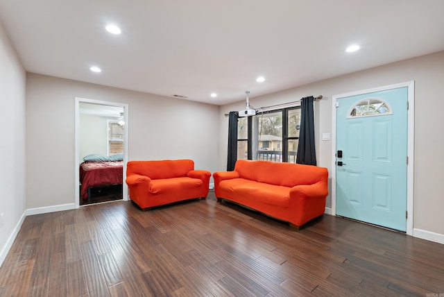 living area with baseboards, visible vents, dark wood-style flooring, and recessed lighting