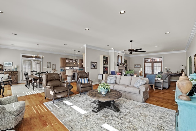 living area featuring light wood-type flooring, ornamental molding, and recessed lighting