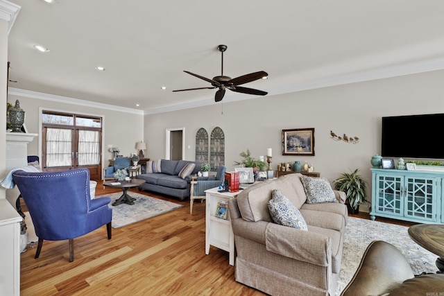 living area featuring ceiling fan, a tile fireplace, recessed lighting, ornamental molding, and light wood finished floors