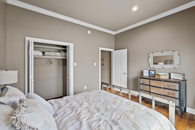 bedroom featuring recessed lighting, wood finished floors, baseboards, a closet, and crown molding