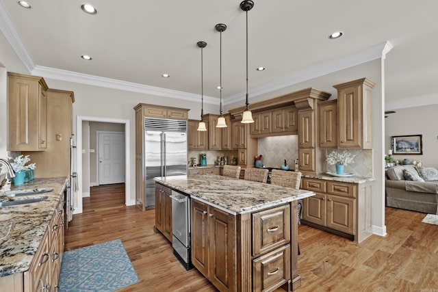 kitchen featuring stainless steel built in fridge, a sink, light wood-style floors, backsplash, and a center island