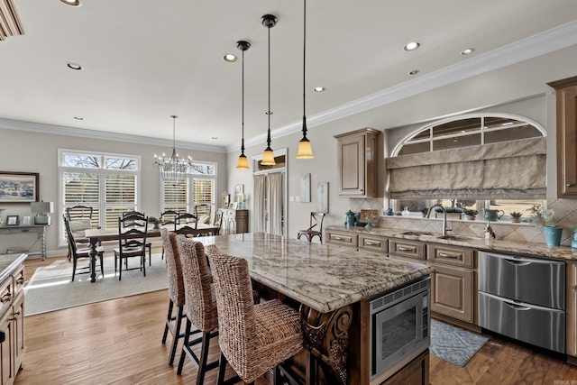 kitchen featuring a center island, backsplash, light stone countertops, stainless steel microwave, and dark wood finished floors