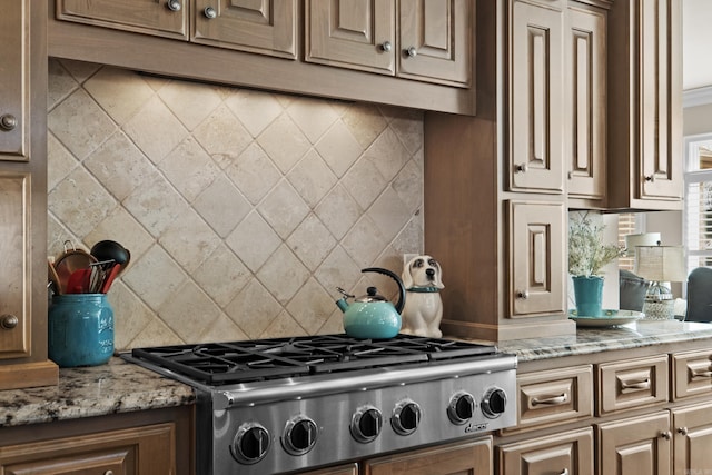 kitchen featuring light stone counters, stainless steel gas cooktop, and decorative backsplash