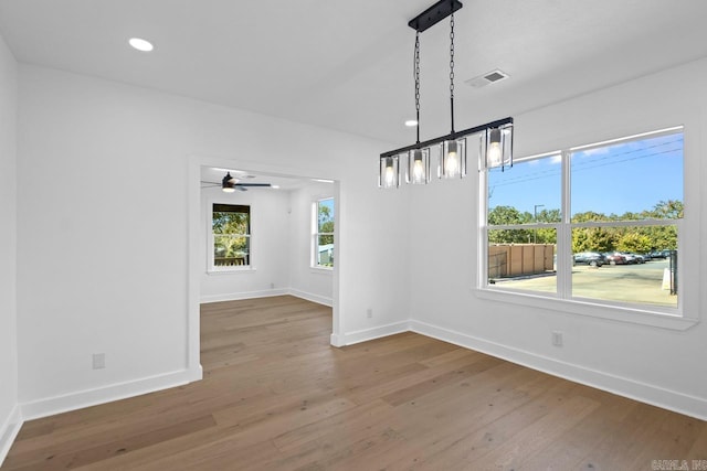 unfurnished dining area with baseboards, visible vents, wood finished floors, and recessed lighting