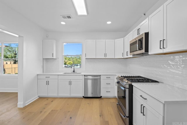 kitchen featuring visible vents, appliances with stainless steel finishes, light countertops, and a sink