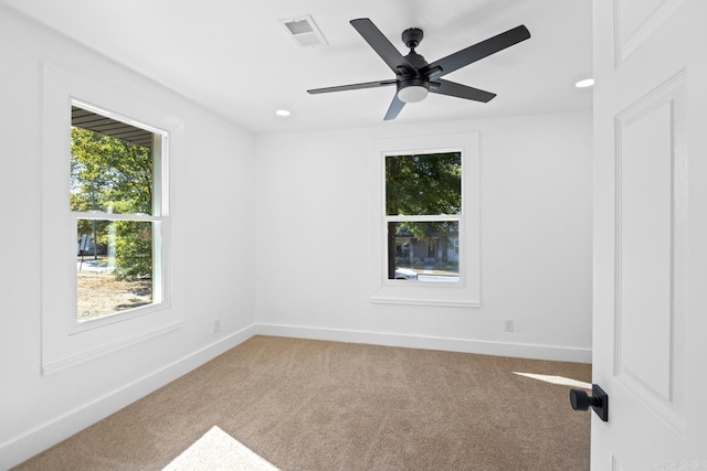 spare room featuring carpet floors, visible vents, and baseboards