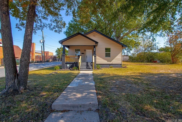 bungalow-style house with covered porch and a front lawn