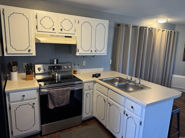 kitchen with electric range, white cabinets, a peninsula, under cabinet range hood, and a sink