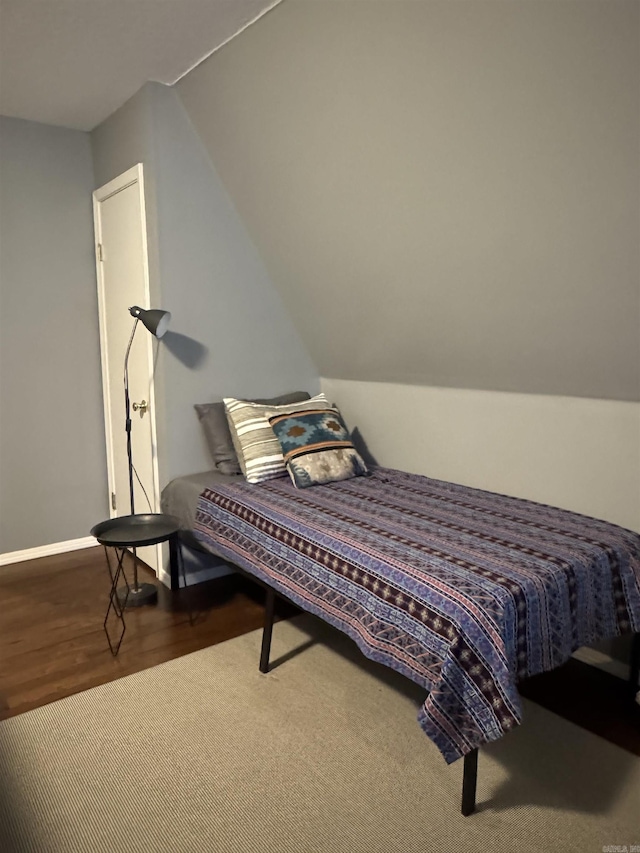 bedroom featuring vaulted ceiling, wood finished floors, and baseboards