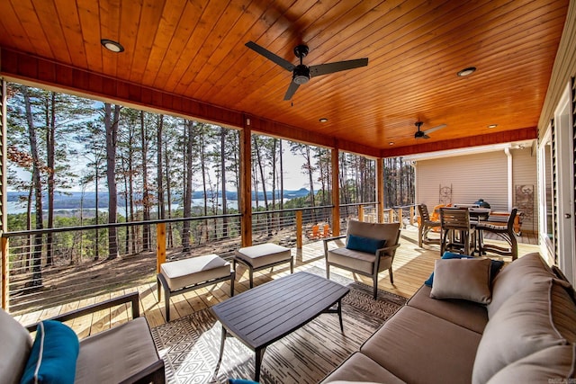 sunroom featuring a ceiling fan and wood ceiling