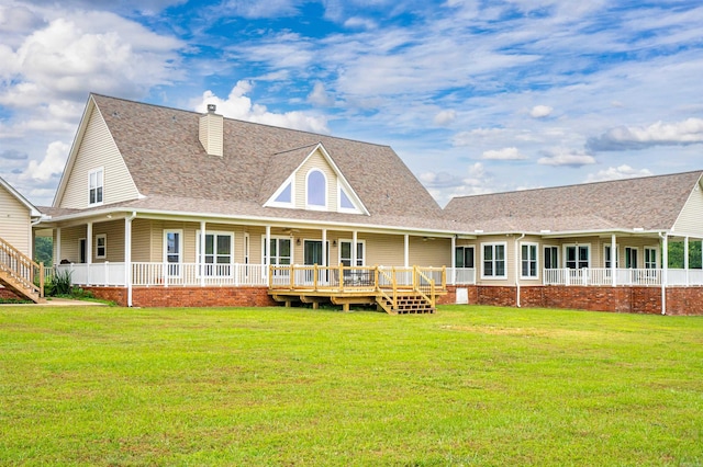 back of house featuring a porch, roof with shingles, a lawn, and a chimney