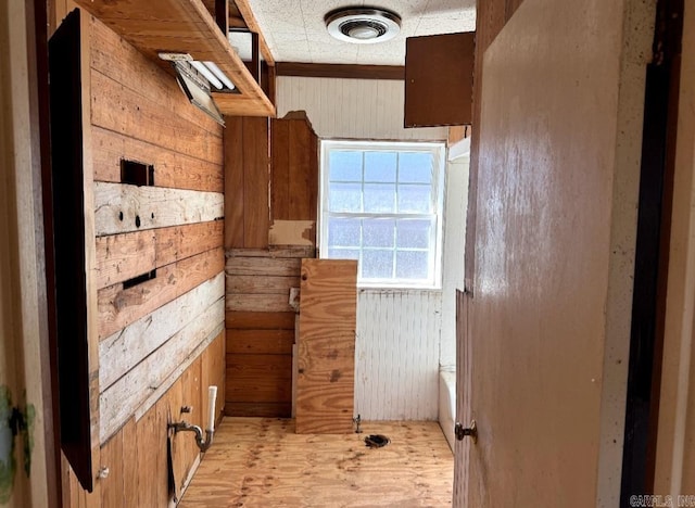 bathroom with wood finished floors, visible vents, and wooden walls