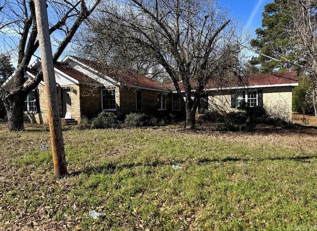 view of front facade featuring brick siding and a front yard