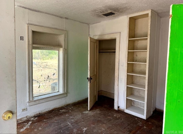 unfurnished bedroom with a closet, visible vents, and a textured ceiling