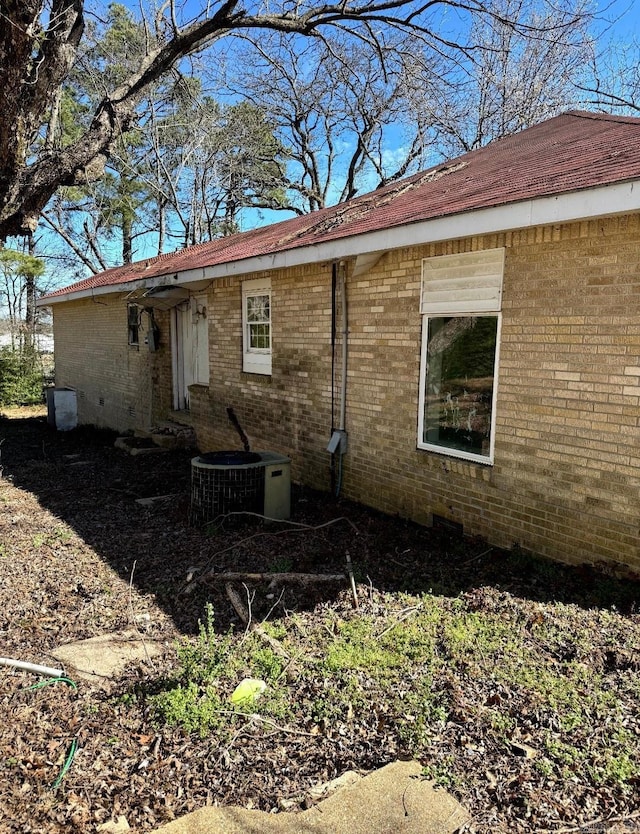 rear view of house with brick siding and central AC unit