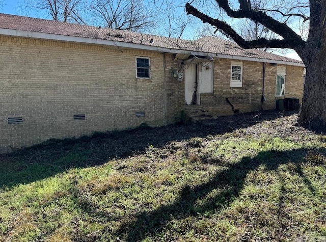 back of property with entry steps, crawl space, brick siding, and central AC