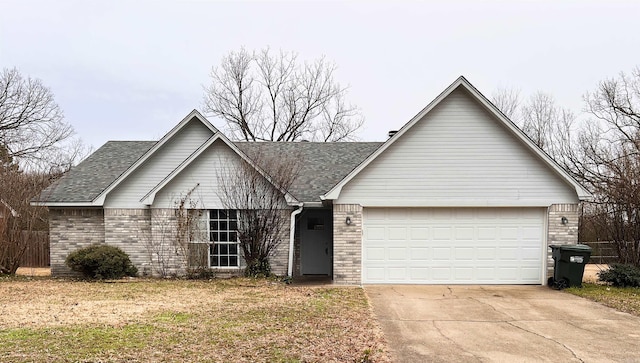 single story home with a garage, concrete driveway, brick siding, and a shingled roof