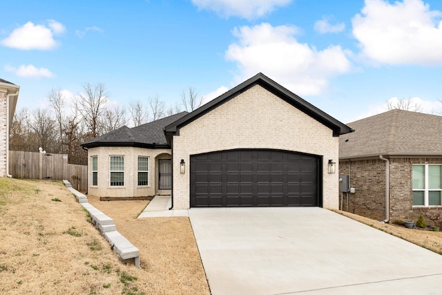 single story home with brick siding, driveway, an attached garage, and fence