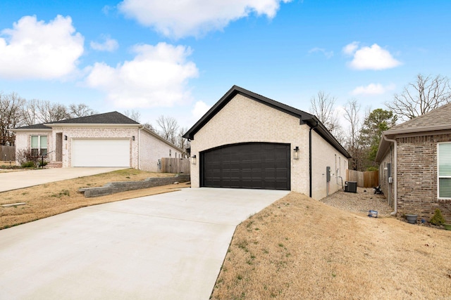 ranch-style home with a garage, fence, central AC, and brick siding