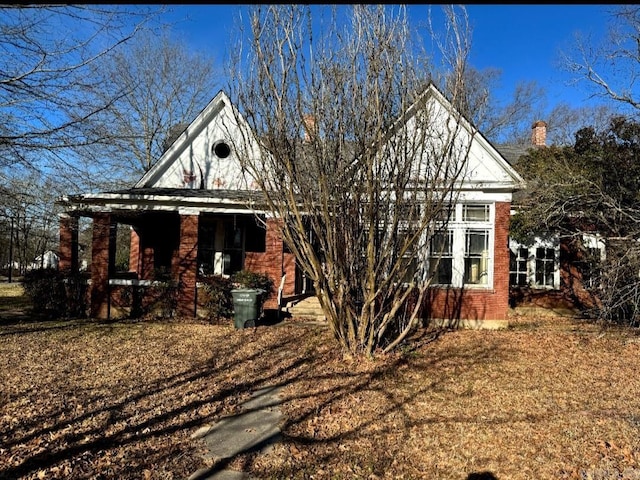 exterior space featuring covered porch and brick siding