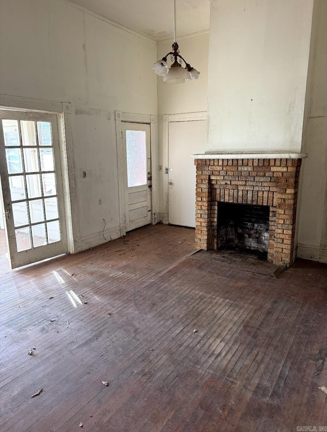 unfurnished living room with hardwood / wood-style flooring, a fireplace, and a high ceiling