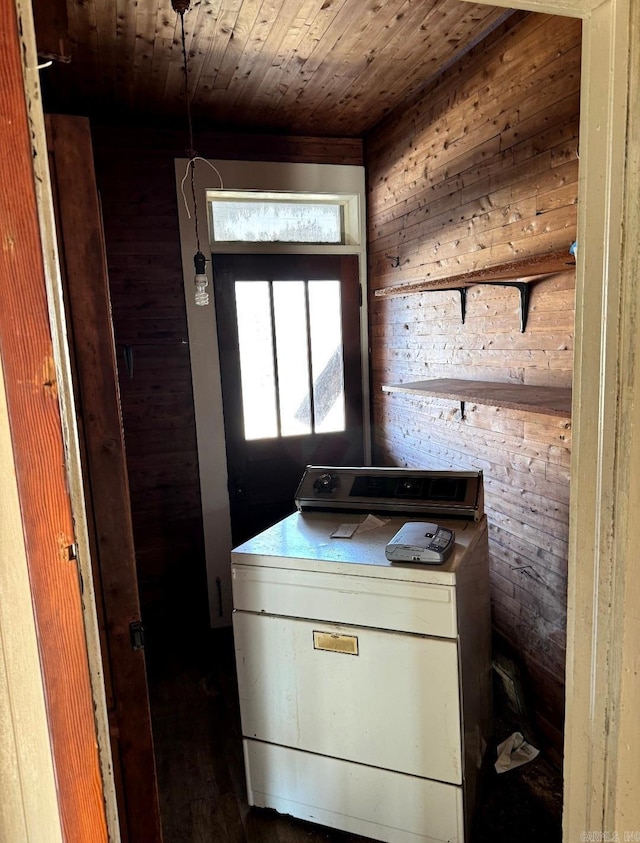 clothes washing area with wooden ceiling, washer / dryer, laundry area, and wood walls