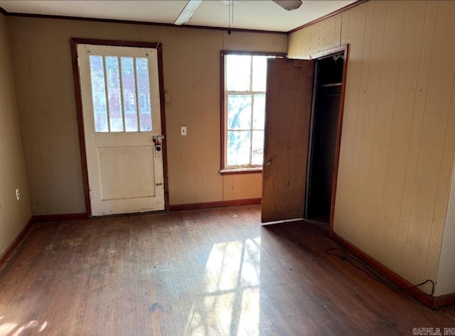 foyer with ornamental molding, hardwood / wood-style flooring, and baseboards