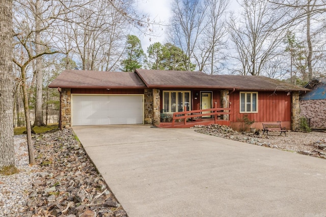 ranch-style house featuring driveway, stone siding, an attached garage, a porch, and board and batten siding