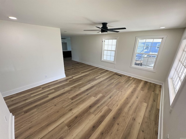 unfurnished room with ceiling fan, baseboards, and wood finished floors