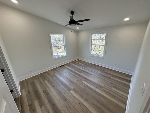 empty room featuring recessed lighting, dark wood-style flooring, a healthy amount of sunlight, and baseboards