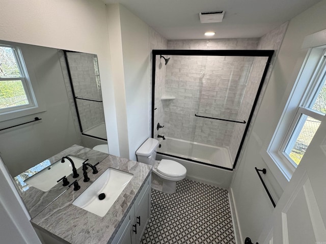 full bathroom with toilet, enclosed tub / shower combo, visible vents, and vanity