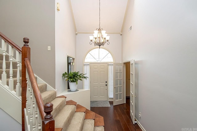 foyer with high vaulted ceiling, stairway, dark wood finished floors, and visible vents