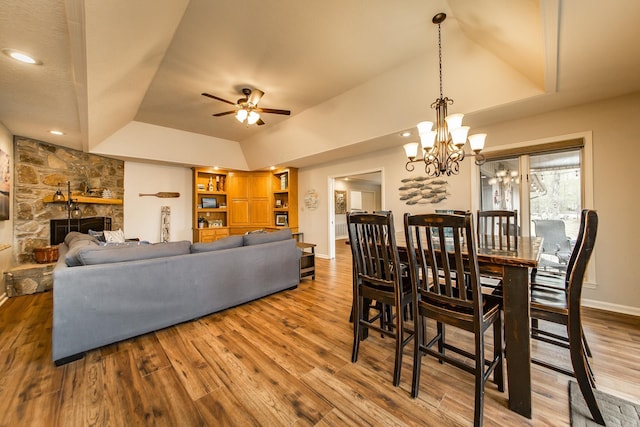 dining area with a raised ceiling, a fireplace, baseboards, and wood finished floors