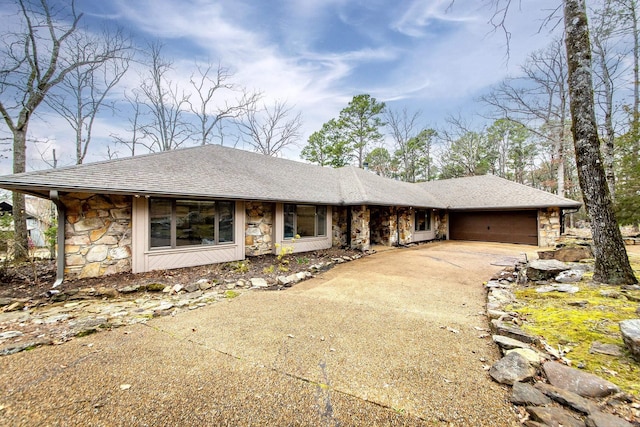 view of front of home featuring a garage, stone siding, a shingled roof, and driveway