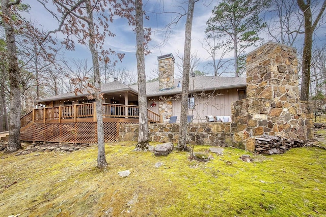 back of house featuring a yard, stairs, a chimney, and a wooden deck