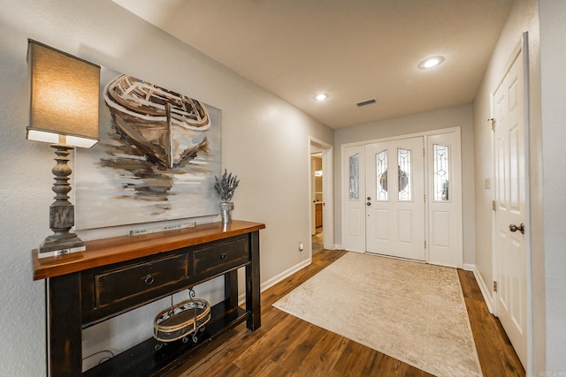 foyer entrance with baseboards, visible vents, dark wood-style flooring, and recessed lighting