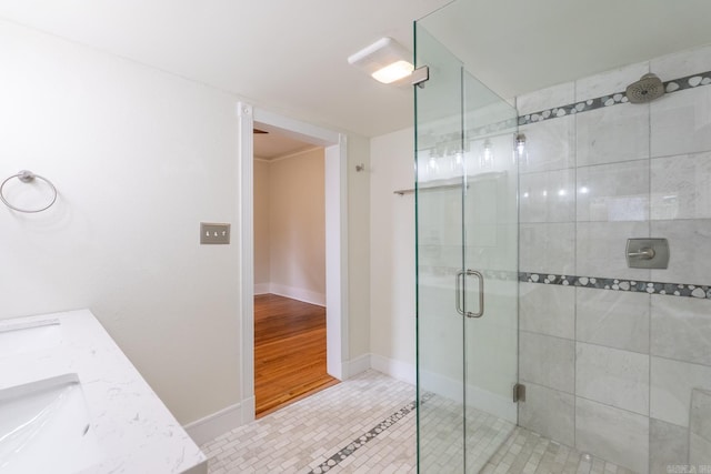 bathroom with a stall shower, a sink, baseboards, and tile patterned floors