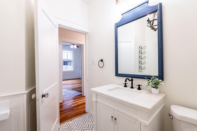 half bathroom featuring vanity, toilet, and wood finished floors