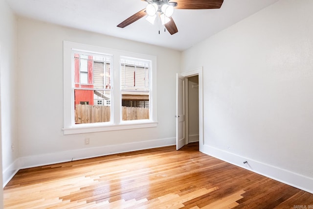 empty room featuring light wood-style floors, ceiling fan, and baseboards