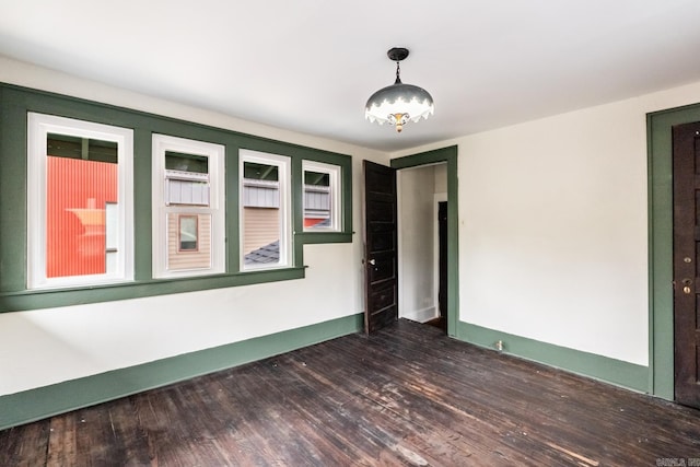 spare room with dark wood-style floors and baseboards