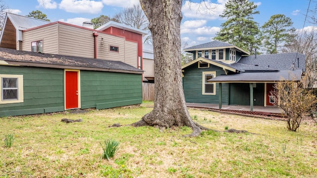 back of house featuring fence, a lawn, and a patio