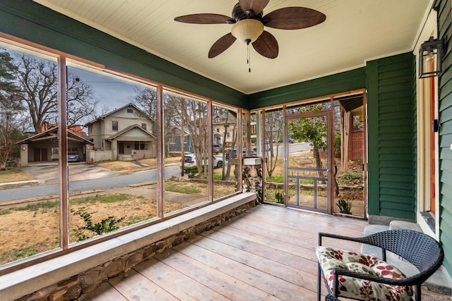 sunroom / solarium with ceiling fan and a residential view