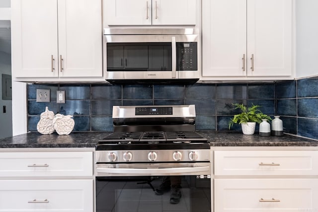 kitchen with tile patterned flooring, appliances with stainless steel finishes, white cabinets, and decorative backsplash