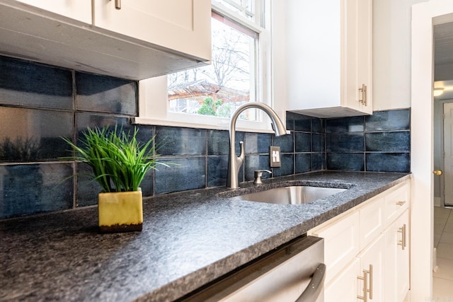 kitchen with tasteful backsplash, white cabinetry, and a sink