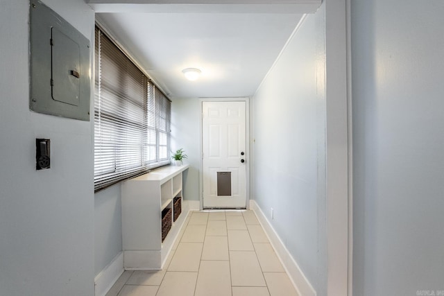 entryway featuring light tile patterned floors, electric panel, and baseboards